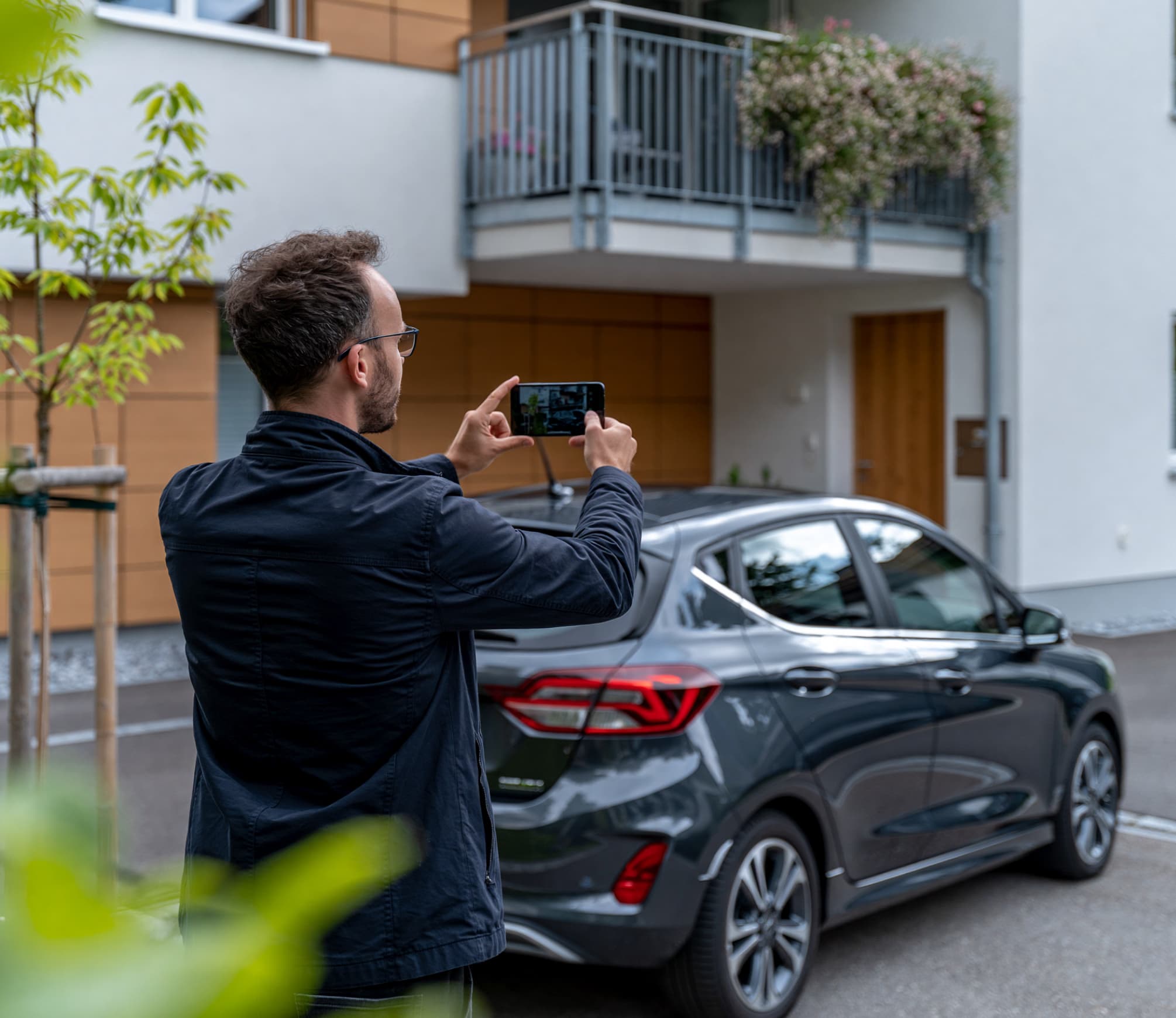 Falschparker blockiert privaten Stellplatz vor einem Mehrfamilienhaus
